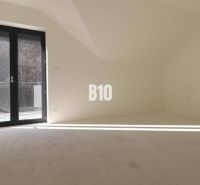 A bright room in a 3-room apartment with large glass doors.