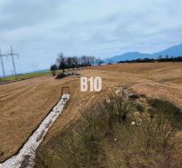 Hilly landscape in Laskár suitable for residential plots, with power lines in the background.