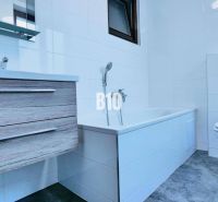 Bathroom in a 3-room apartment with a bathtub, sink, toilet, and floor with a wooden decor.
