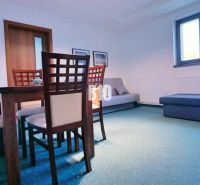 Dining room in a 3-room apartment with wooden furniture and blue flooring.