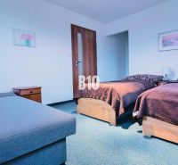 Bedroom in a 3-room apartment with two beds, nightstands, and a sofa.