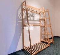 A wooden stand with hangers in a 3-room apartment on a dark carpet.