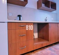 A kitchen unit with a wooden decor floor in a 3-room apartment.