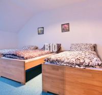 A bedroom with three beds in a 3-room apartment. Wooden decorations, green carpet.