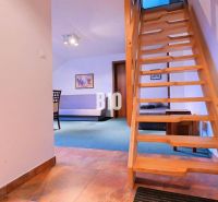 Wooden staircase in a 3-room apartment with a wood-patterned floor.