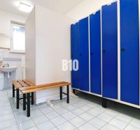 Locker room in the production area with blue lockers and a mirror above the sink.