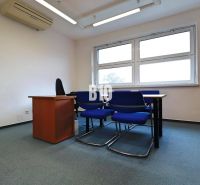 Offices with blue chairs, a table, white walls, and windows.