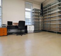 Office in a production area with shelves, a computer, and a chair.