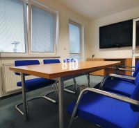 Conference room in offices with blue chairs and a table with a wooden decor.