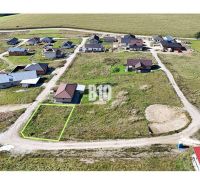 A residential plot in Necpaly, nestled among houses, ready for construction.