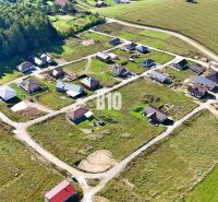 Aerial view of building plots in Necpaly surrounded by forests and agricultural landscape.