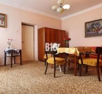 Living room in a family house, carpets, dark wood furniture, paintings on the walls.