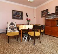 Dining room in a family house with wooden furniture, yellow chairs, carpets.