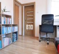 Library, desk, and chair in a family house with a wood-patterned floor.
