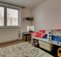 Children's room with a bed and toys, floor with wooden decor in a 3-room apartment.