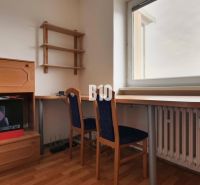A workspace with furniture and a chair, a floor with a wooden decor, a wall with a shelf.