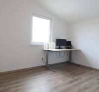 A room in a family house with a wooden decor floor and a work desk.