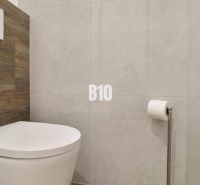 A bathroom with a toilet and wooden decor in a 3-room apartment.