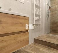 Bathroom in a 3-room apartment with flooring and tiles featuring a wood design.