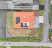 A family house in Beladice with a red roof and solar panels on a grassy plot.