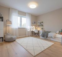Children's room in a family house with a wooden decor floor and white furniture.