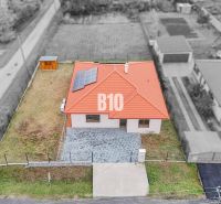 A family house in Beladice with solar panels on the roof and a landscaped plot.