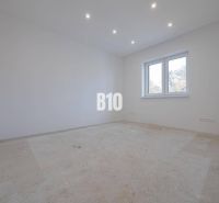 An empty room with white walls and a window, ready for flooring in a family house.