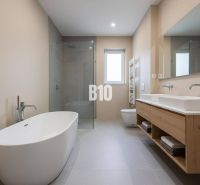 A bathroom with a freestanding bathtub and a shower in a family house.