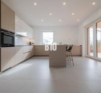 Kitchen in a family house with an island and bar stools.