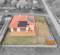 A family house in Beladice with solar panels and a fenced garden.