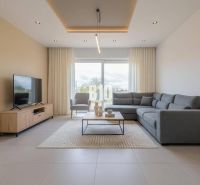 Living room with a comfortable sofa, television, and a large window in a family house.