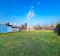 A plot of land near a family house in Sľažany with metal structures and a grassy area.