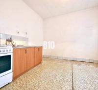A kitchen in a family house with a kitchen unit, a stove, and a tiled floor.