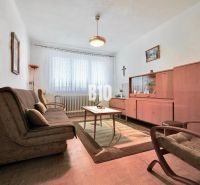 A living room in a 3-room apartment with vintage furniture and a wooden decor floor.