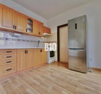 A kitchen with wooden cabinets and a wooden decor floor in a 3-room apartment.