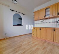 A kitchen in a 3-room apartment with a wooden decor floor and built-in cabinets.
