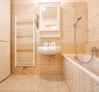 A bathroom with a bathtub and a sink in a 3-room apartment with tiles.