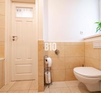 A bathroom with a wall-hung toilet and beige tiles in a 3-room apartment.