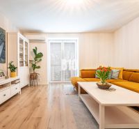 Living room in a 3-room apartment with a yellow sofa and a wooden decor floor.
