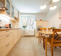 A kitchen in a 3-room apartment with a wooden decor floor and wooden furniture.