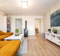Living room of a three-room apartment with a wooden decor floor and a comfortable sofa.