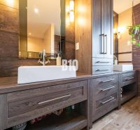 A family house bathroom with cabinets and a wooden decor floor.