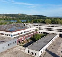 Production premises in Levice with abandoned buildings surrounded by nature and a body of water.