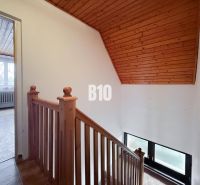 Family house with wooden railing, floor with wooden decor, and room with a window.