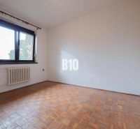 An empty room with a wooden floor in a family house, large window.