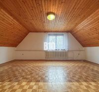 Attic room in a family house with a wooden ceiling and a floor with a wooden decor.