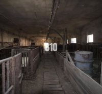 Old production facilities with cages and barrels, darkened windows.