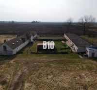 Manufacturing premises in Ture with older buildings, in the middle of agricultural landscape.
