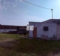 Production premises in the exterior in the town of Turá with simple buildings and a grassy area.