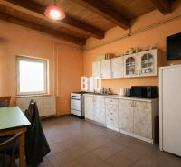 Kitchen space with simple cabinets, appliances, and a dining table.